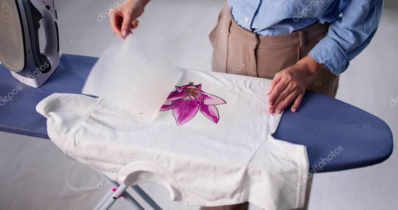 Person bedruckt ein T-Shirt in einer kleinen Werkstatt