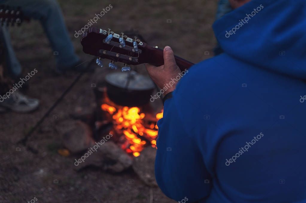 Musiker mit Gitarren am Lagerfeuer drehen ein Musikvideo