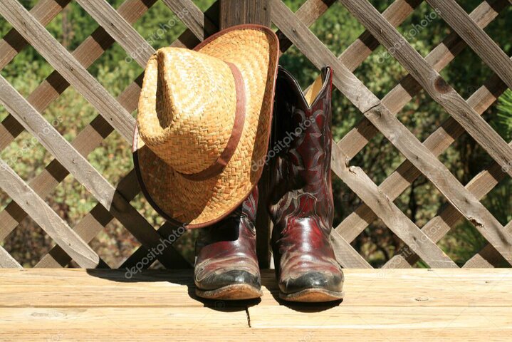 Cowboyhut, Boots und Western-Deko auf einem Holztisch